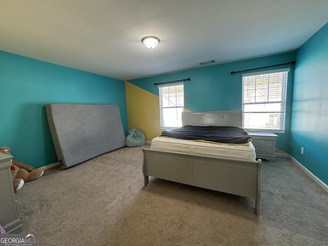 bedroom featuring multiple windows and light carpet