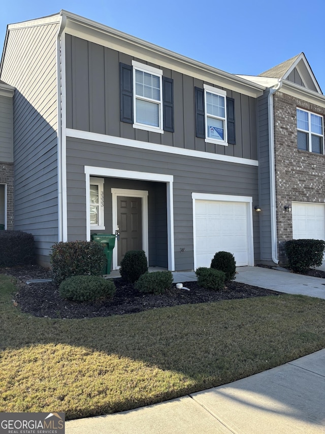 townhome / multi-family property with a front yard and a garage