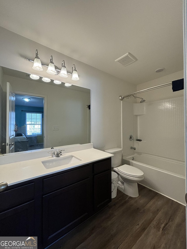 full bathroom with bathing tub / shower combination, toilet, vanity, and hardwood / wood-style flooring