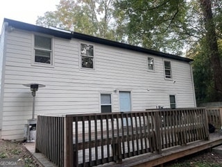 rear view of house featuring a wooden deck