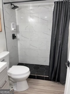 bathroom with a shower with curtain, vanity, toilet, and wood-type flooring