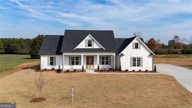 modern farmhouse style home featuring covered porch and a front yard