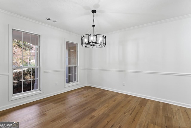 unfurnished dining area featuring crown molding, dark wood-type flooring, and a notable chandelier