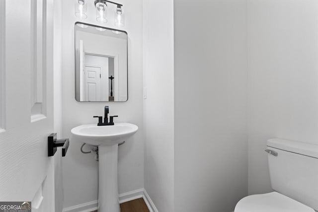 bathroom featuring hardwood / wood-style flooring and toilet