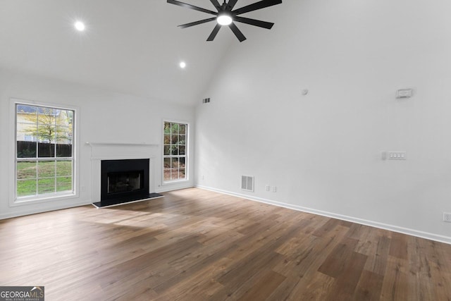 unfurnished living room featuring hardwood / wood-style floors, ceiling fan, and high vaulted ceiling