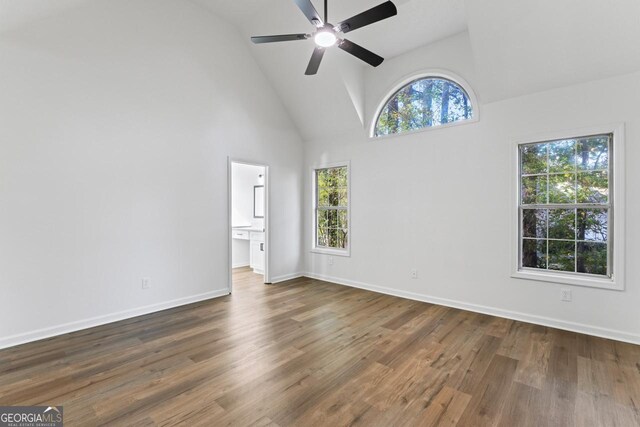 spare room featuring dark hardwood / wood-style floors, high vaulted ceiling, and ceiling fan