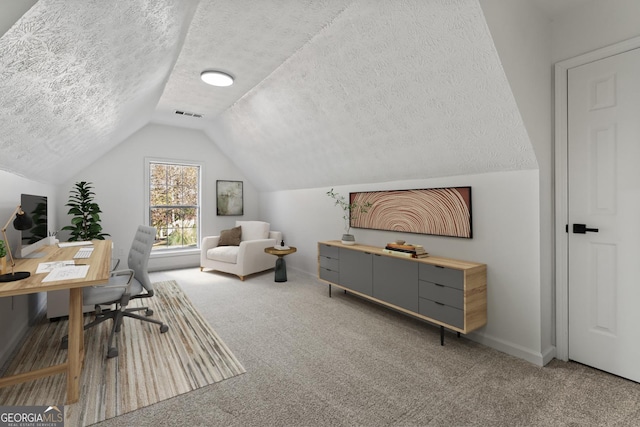 carpeted office with lofted ceiling and a textured ceiling