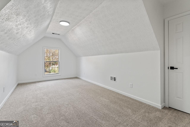 bonus room with carpet flooring, a textured ceiling, and lofted ceiling