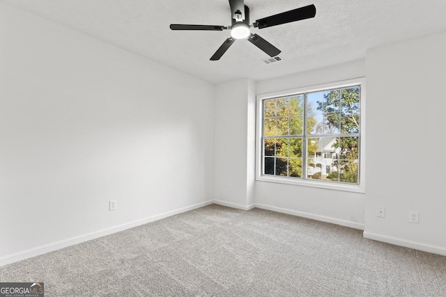 carpeted empty room featuring a textured ceiling and ceiling fan