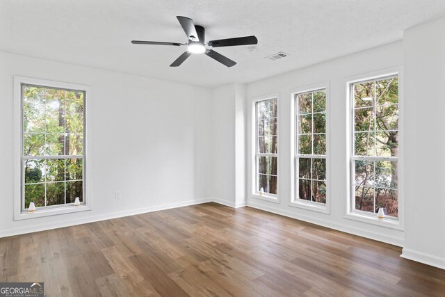 spare room featuring hardwood / wood-style floors, a textured ceiling, and ceiling fan