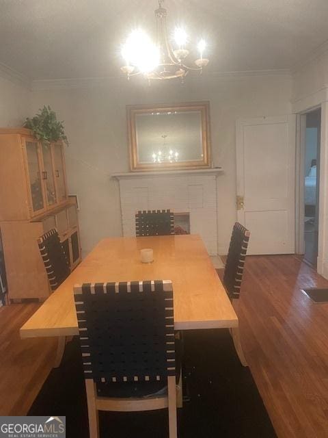 dining room with hardwood / wood-style floors, crown molding, and an inviting chandelier