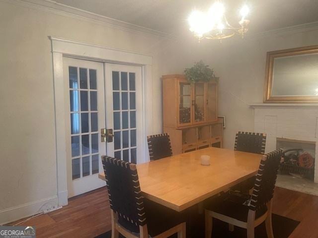 dining room featuring french doors, dark hardwood / wood-style floors, ornamental molding, and a notable chandelier