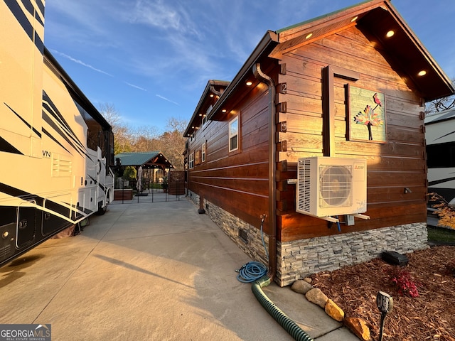 view of side of home with ac unit and a patio