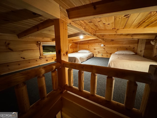 interior space featuring beam ceiling, wooden ceiling, and wooden walls