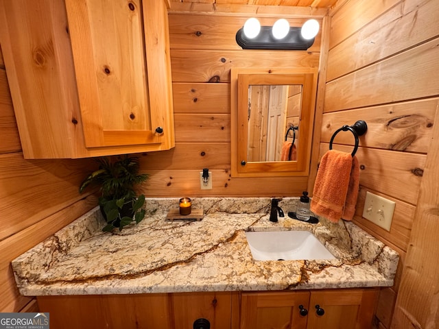 bathroom with vanity and wood walls