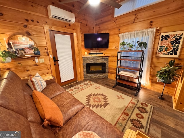 living room featuring ceiling fan, a stone fireplace, dark hardwood / wood-style flooring, an AC wall unit, and wood walls