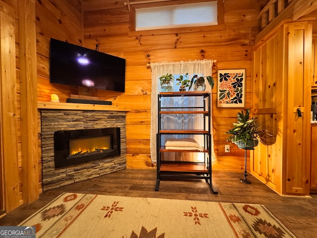 living area featuring hardwood / wood-style flooring, wood walls, and a fireplace