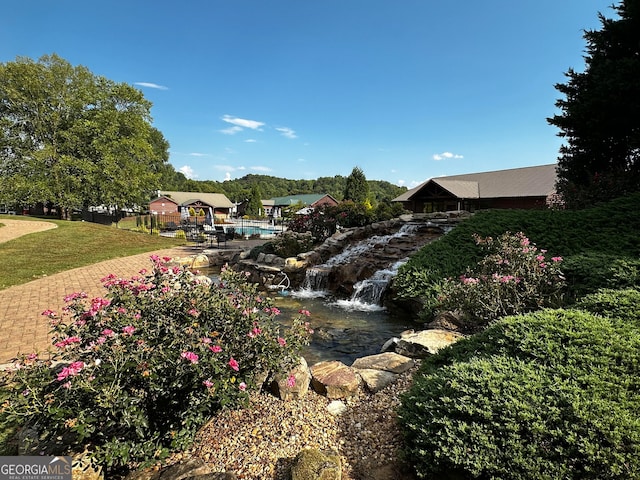 surrounding community with a lawn and a swimming pool