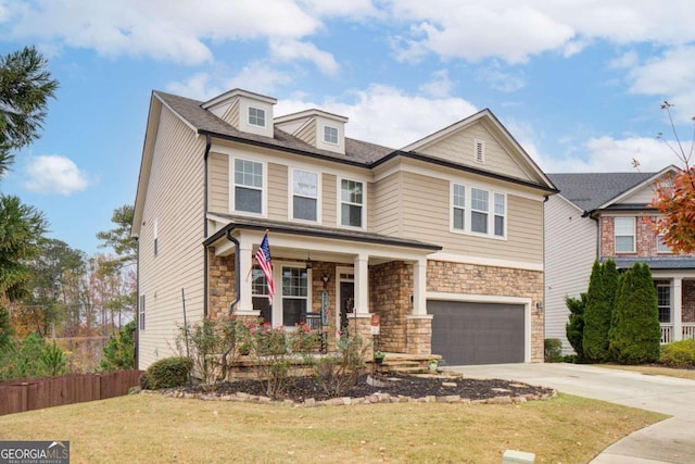 view of front of house with a porch, a front yard, and a garage