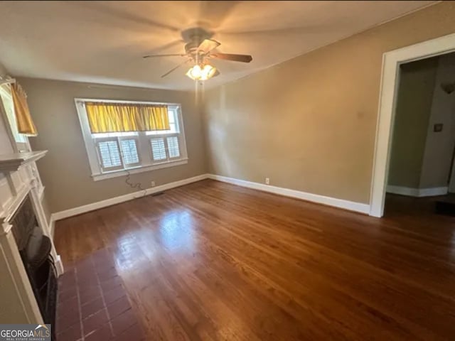 unfurnished living room with ceiling fan and dark hardwood / wood-style flooring