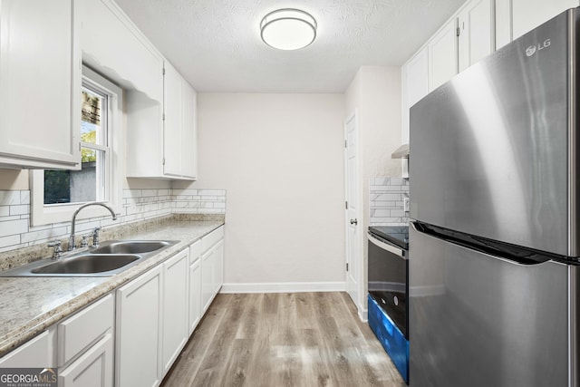 kitchen featuring backsplash, white cabinetry, sink, and stainless steel appliances