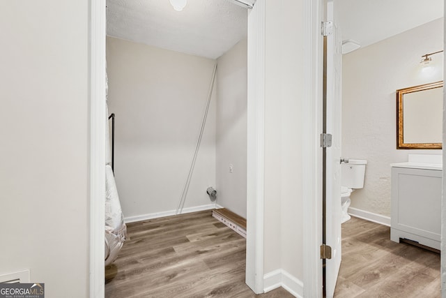 bathroom featuring vanity, hardwood / wood-style floors, a textured ceiling, and toilet