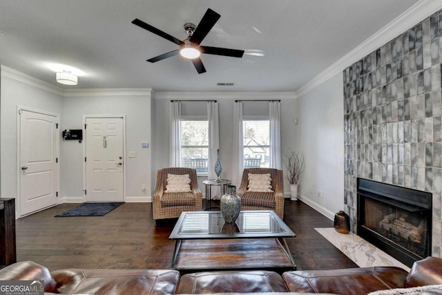 living room with a fireplace, ornamental molding, and dark wood-type flooring