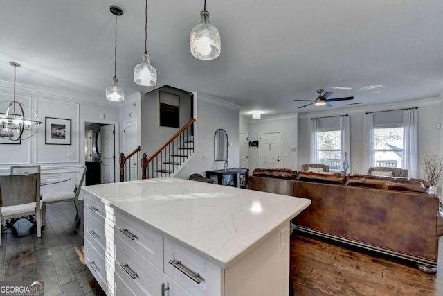 kitchen featuring white cabinets, dark wood-type flooring, decorative light fixtures, and ornamental molding