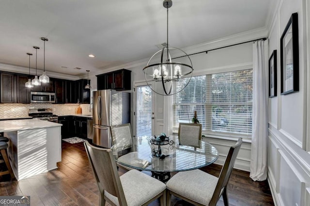 dining space with dark wood-type flooring, a notable chandelier, and ornamental molding