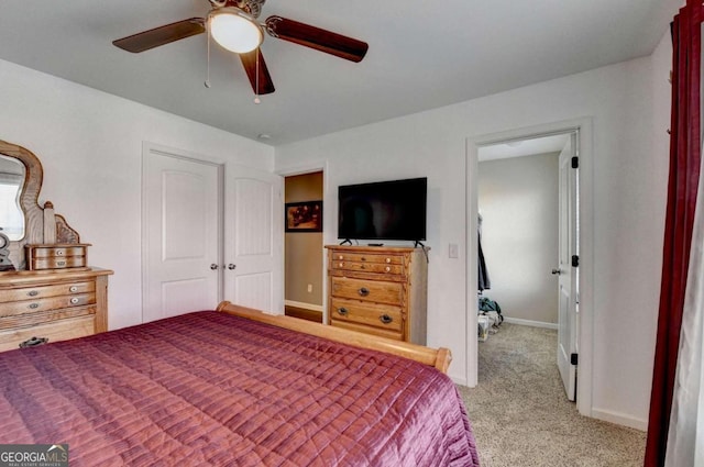 bedroom with a closet, ceiling fan, and light colored carpet