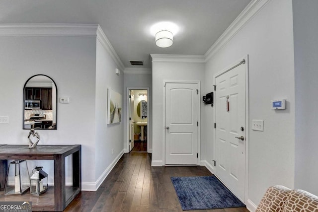 foyer entrance featuring ornamental molding and dark wood-type flooring