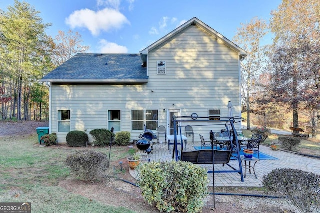 back of house with an outdoor living space with a fire pit and a patio area