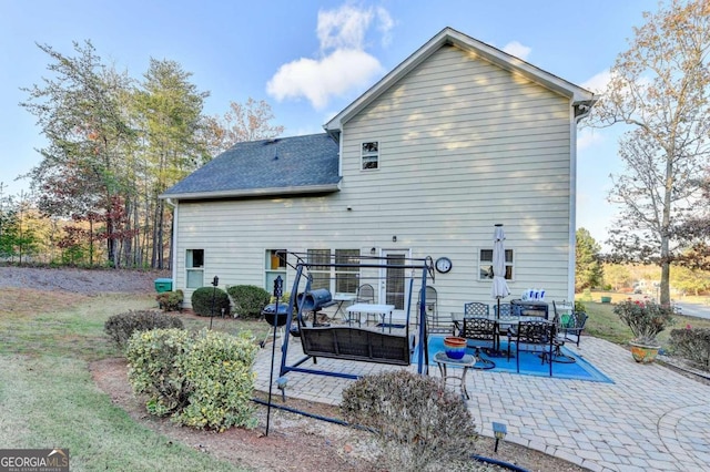 back of house featuring an outdoor living space, a patio, and a lawn