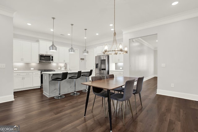 dining space featuring a chandelier, dark hardwood / wood-style floors, crown molding, and sink