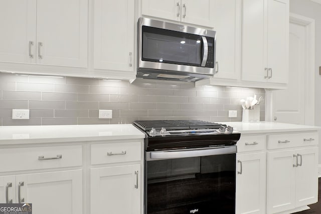 kitchen with white cabinets, decorative backsplash, and black range with electric stovetop