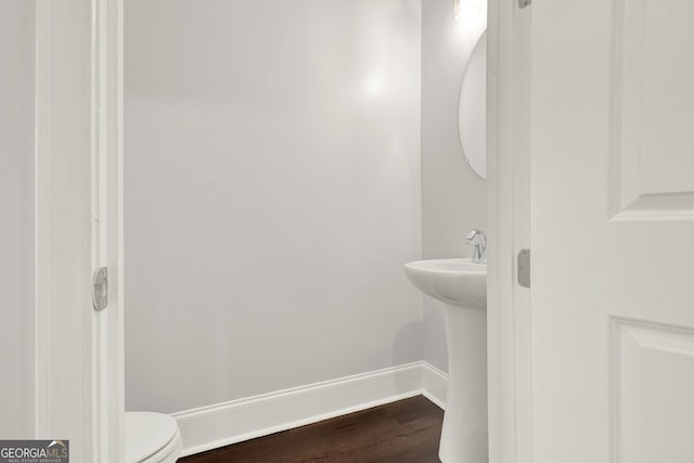 bathroom with hardwood / wood-style floors and toilet