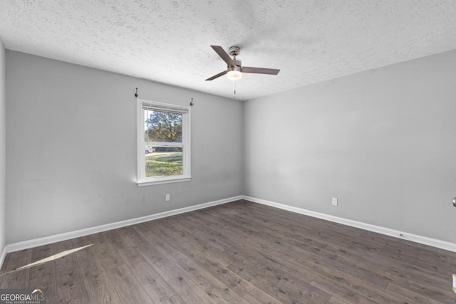 empty room with a textured ceiling, dark hardwood / wood-style flooring, and ceiling fan