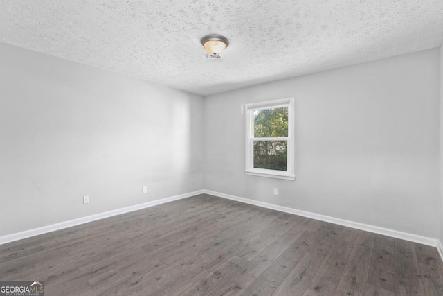 unfurnished room with dark wood-type flooring and a textured ceiling