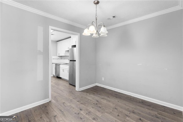 unfurnished dining area featuring ornamental molding, light hardwood / wood-style floors, and a notable chandelier