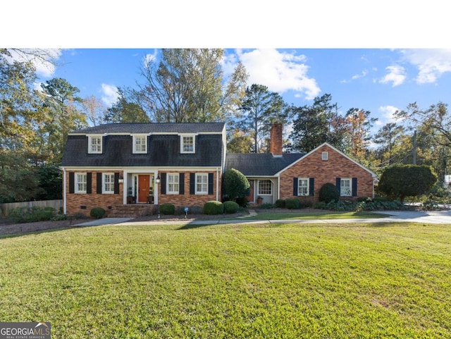 view of front of house with crawl space, a front yard, a chimney, and brick siding