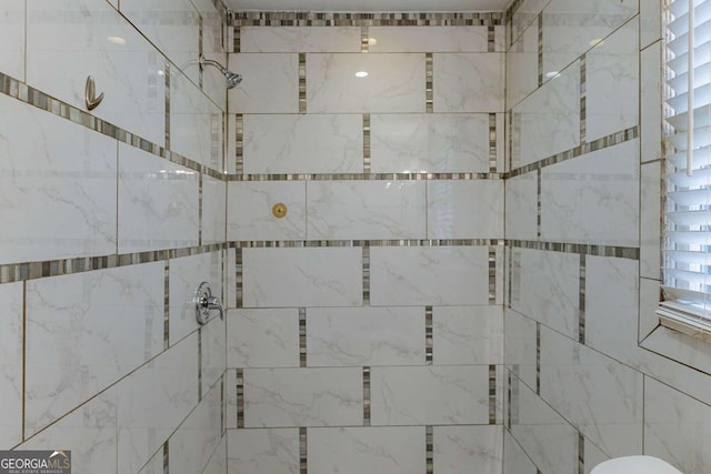 interior details featuring tiled shower