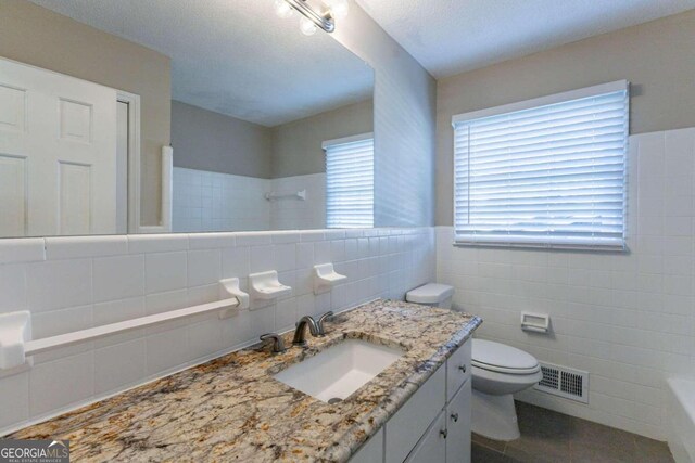 3619 Colonial Trl, Douglasville, GA 30135 - bathroom with vanity, tile patterned floors, toilet, tile walls, and walk in shower