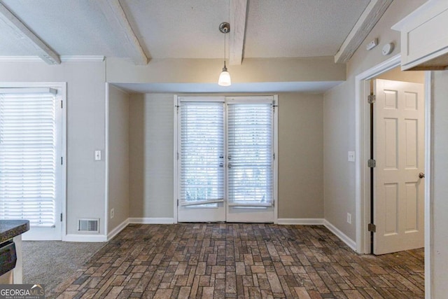 unfurnished dining area with beamed ceiling, a textured ceiling, and crown molding