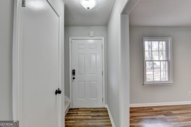 doorway to outside featuring light hardwood / wood-style floors and a textured ceiling