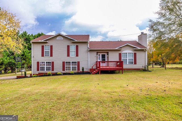 rear view of property featuring a lawn and a deck