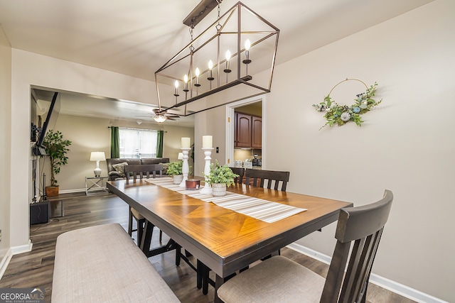 dining room with dark hardwood / wood-style flooring and ceiling fan with notable chandelier