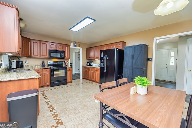 kitchen featuring black appliances, light tile patterned floors, and sink