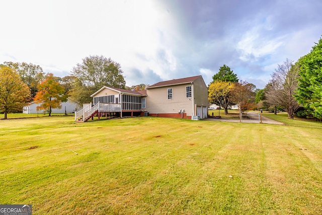 back of house featuring a sunroom and a yard