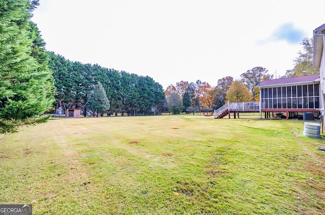 view of yard featuring a sunroom and a deck