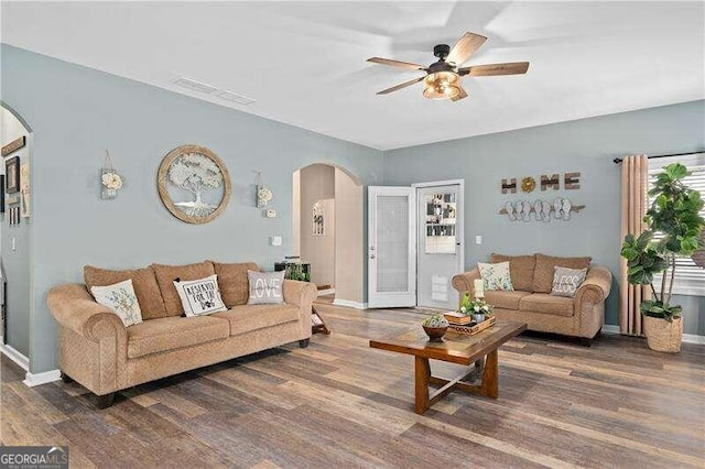 living room with dark hardwood / wood-style floors and ceiling fan